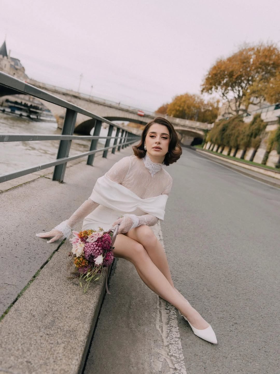 Mariée élégante sur berge urbaine